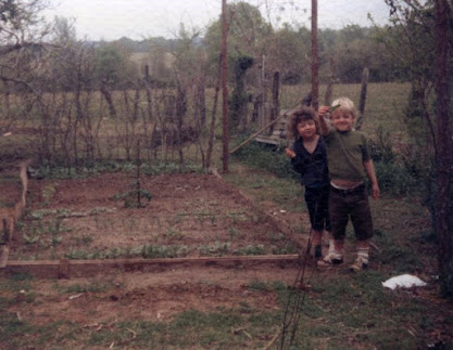 Two children standing in a garden on a farm.