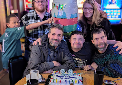 Sam, Shawna, and family gathered around a birthday cake